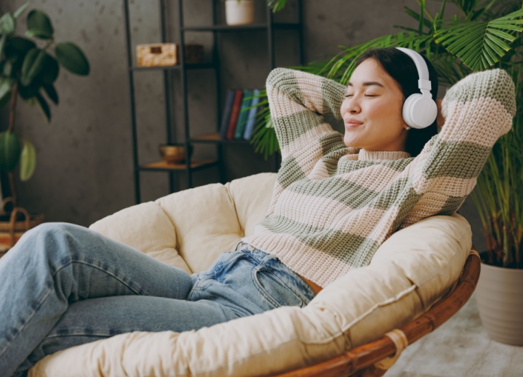 A woman relaxing with headphones on.