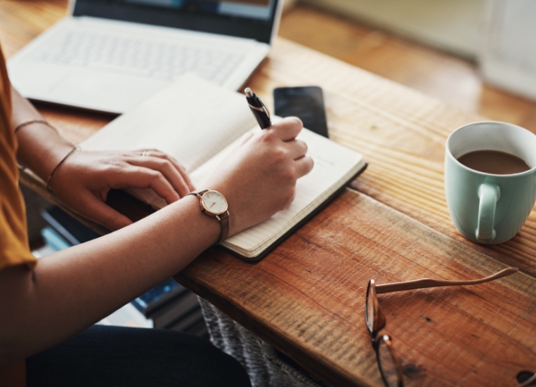 A woman making notes in a diary.