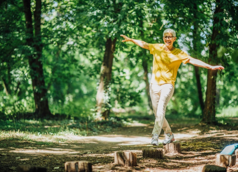 A woman doing balancing exercises outdoors.